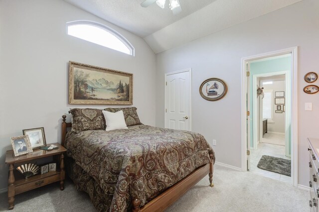 carpeted bedroom featuring connected bathroom, vaulted ceiling, and ceiling fan