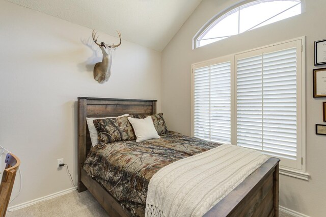 bedroom featuring lofted ceiling and light colored carpet