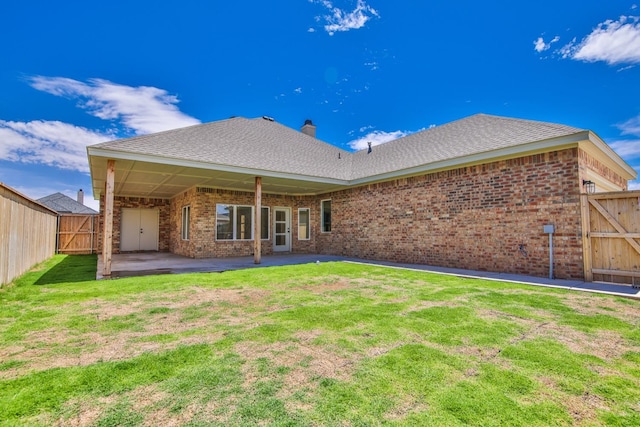 back of house featuring a lawn and a patio