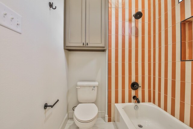 bathroom featuring tiled shower / bath combo and toilet