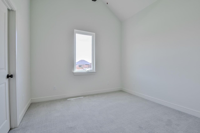 carpeted empty room with lofted ceiling