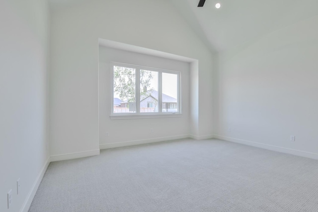 unfurnished room featuring light carpet and high vaulted ceiling