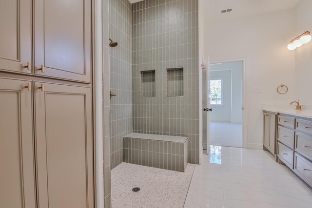 bathroom featuring vanity and tiled shower