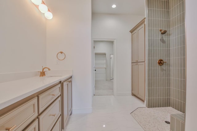 bathroom with vanity and a tile shower