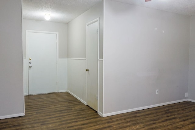 hallway featuring dark wood-type flooring and a textured ceiling