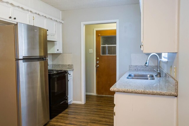 kitchen featuring dark hardwood / wood-style floors, sink, white cabinets, stainless steel fridge, and electric range