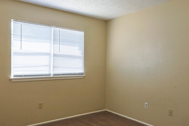 carpeted empty room with a textured ceiling