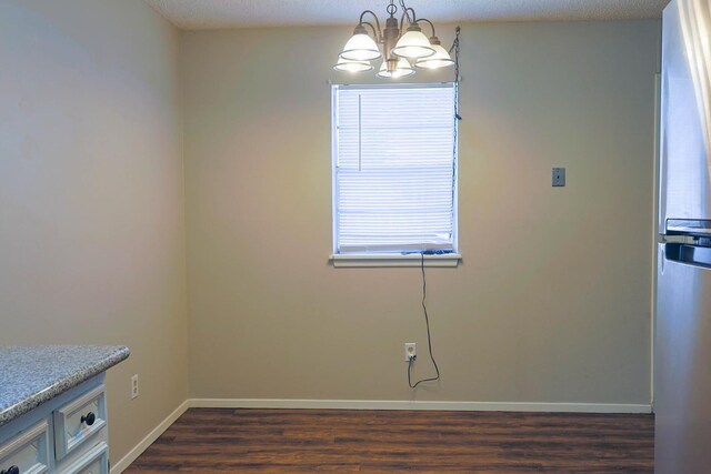 interior space with an inviting chandelier, dark hardwood / wood-style floors, and a textured ceiling