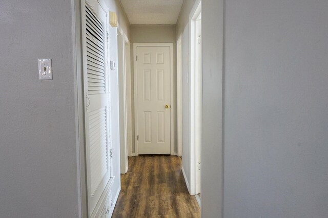 corridor with dark hardwood / wood-style flooring