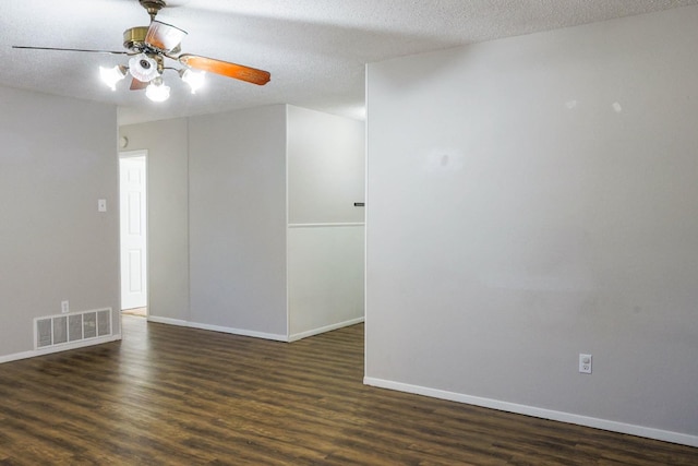 spare room with dark wood-type flooring, ceiling fan, and a textured ceiling