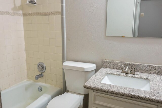 full bathroom with tiled shower / bath combo, vanity, and toilet