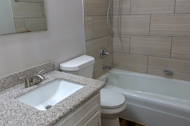 full bathroom featuring vanity, tiled shower / bath combo, and toilet