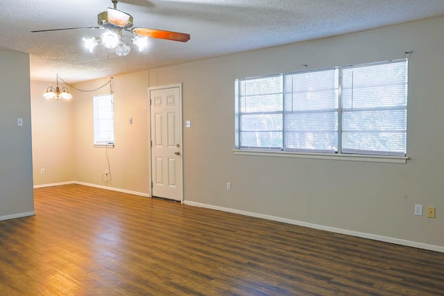 empty room featuring ceiling fan with notable chandelier, a textured ceiling, and dark hardwood / wood-style flooring