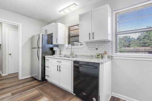 5408 22nd St, Lubbock, TX 79407 - kitchen with backsplash, a sink, dark wood-style floors, freestanding refrigerator, and black dishwasher