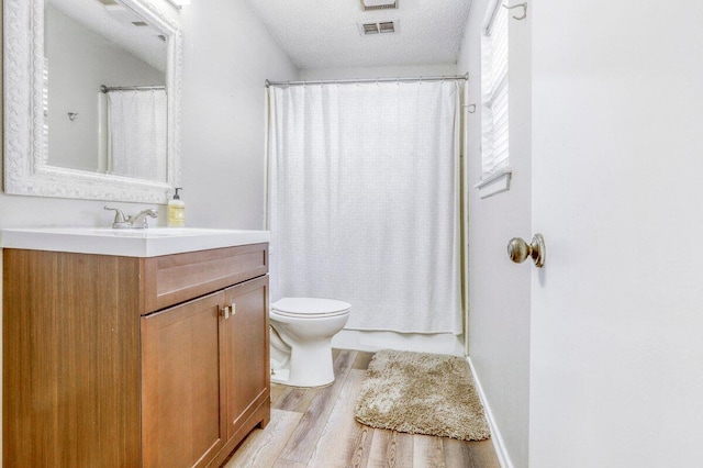 5408 22nd St, Lubbock, TX 79407 - bathroom with vanity, toilet, a textured ceiling, visible vents, and wood finished floors