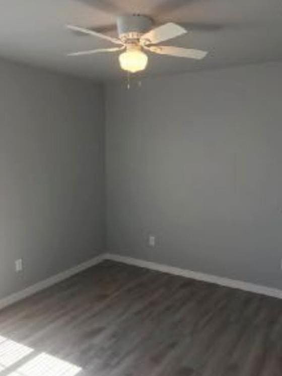 spare room featuring ceiling fan and dark hardwood / wood-style flooring