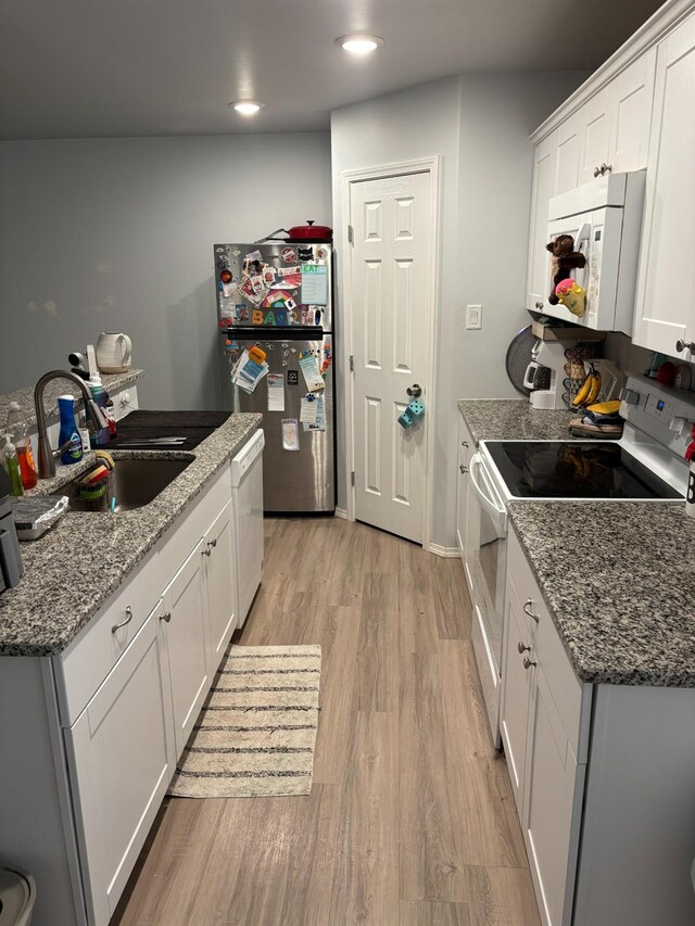 kitchen featuring sink, stone countertops, light wood-type flooring, white appliances, and white cabinets