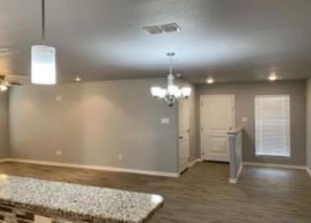 kitchen with pendant lighting, dark hardwood / wood-style floors, and a chandelier