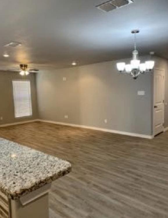 interior space featuring hanging light fixtures, a kitchen island, dark hardwood / wood-style floors, and an inviting chandelier