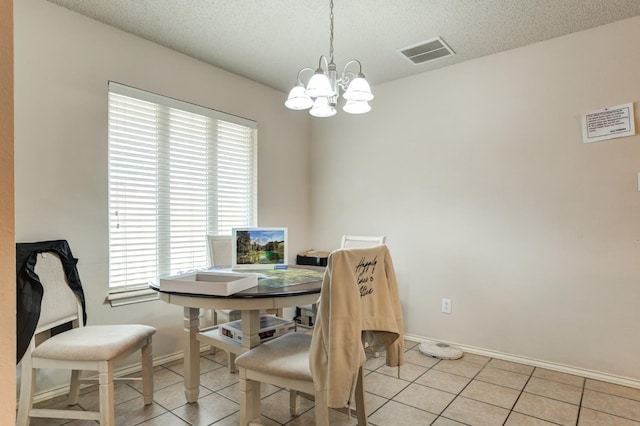 tiled dining area featuring a textured ceiling and a chandelier