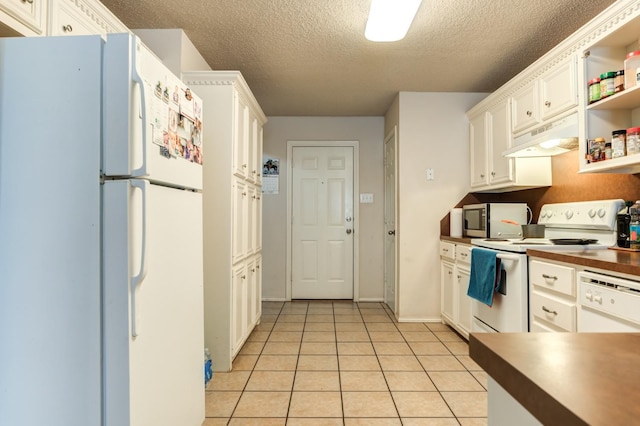 kitchen with light tile patterned flooring, a textured ceiling, white cabinets, and white appliances