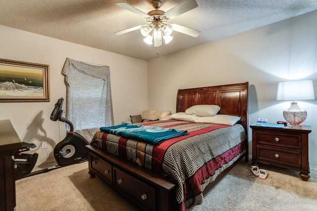 carpeted bedroom featuring ceiling fan and a textured ceiling