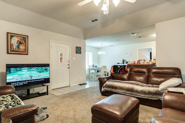 tiled living room with ceiling fan with notable chandelier and a textured ceiling