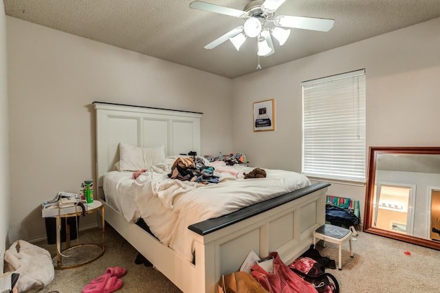 carpeted bedroom with ceiling fan and a textured ceiling