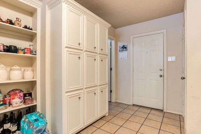 interior space with a textured ceiling and light tile patterned flooring