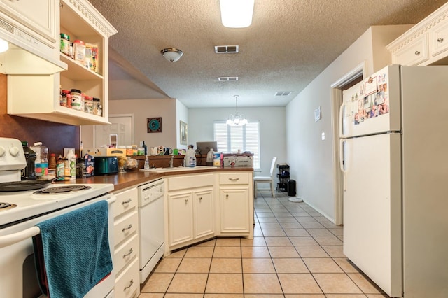 kitchen featuring light tile patterned floors, white appliances, hanging light fixtures, white cabinets, and kitchen peninsula