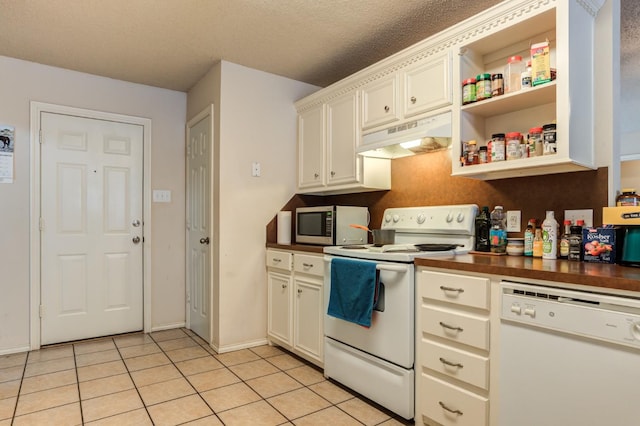 kitchen featuring light tile patterned flooring, white appliances, and a textured ceiling