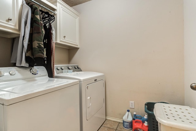 clothes washing area featuring cabinets, separate washer and dryer, and light tile patterned floors