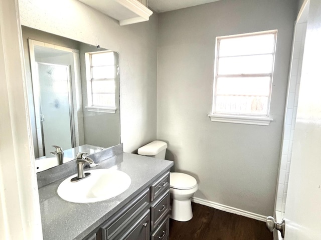 bathroom with vanity, a shower, hardwood / wood-style floors, and toilet