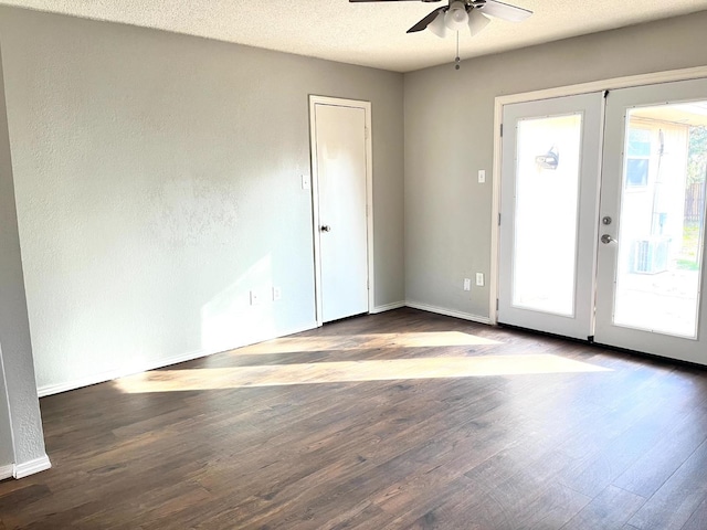 empty room with ceiling fan, wood-type flooring, french doors, and a textured ceiling