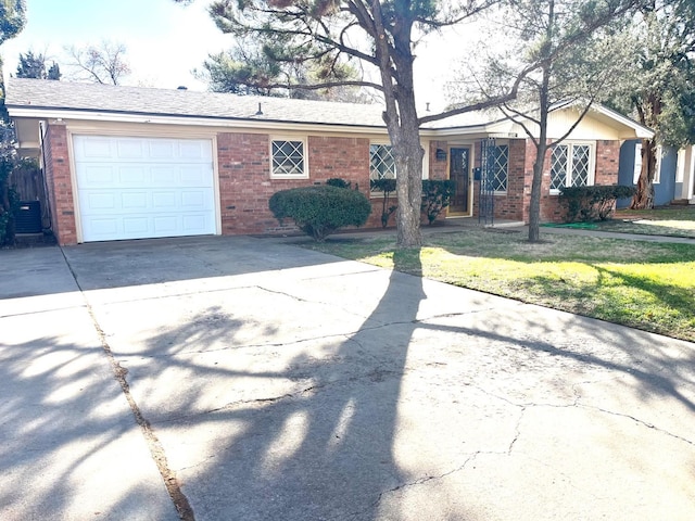 ranch-style house featuring central AC, a garage, and a front yard