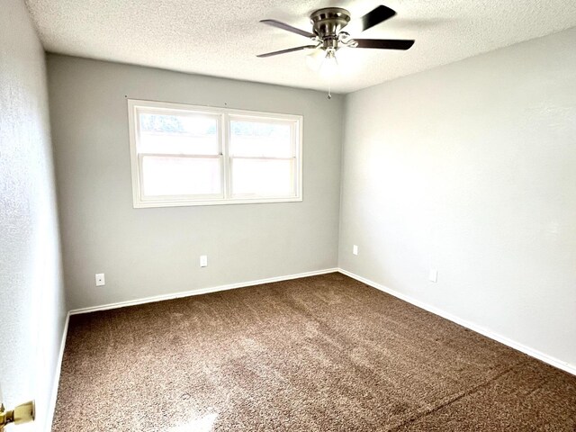 carpeted spare room featuring ceiling fan and a textured ceiling