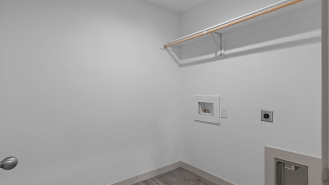 clothes washing area with wood finished floors, hookup for a washing machine, hookup for an electric dryer, baseboards, and laundry area