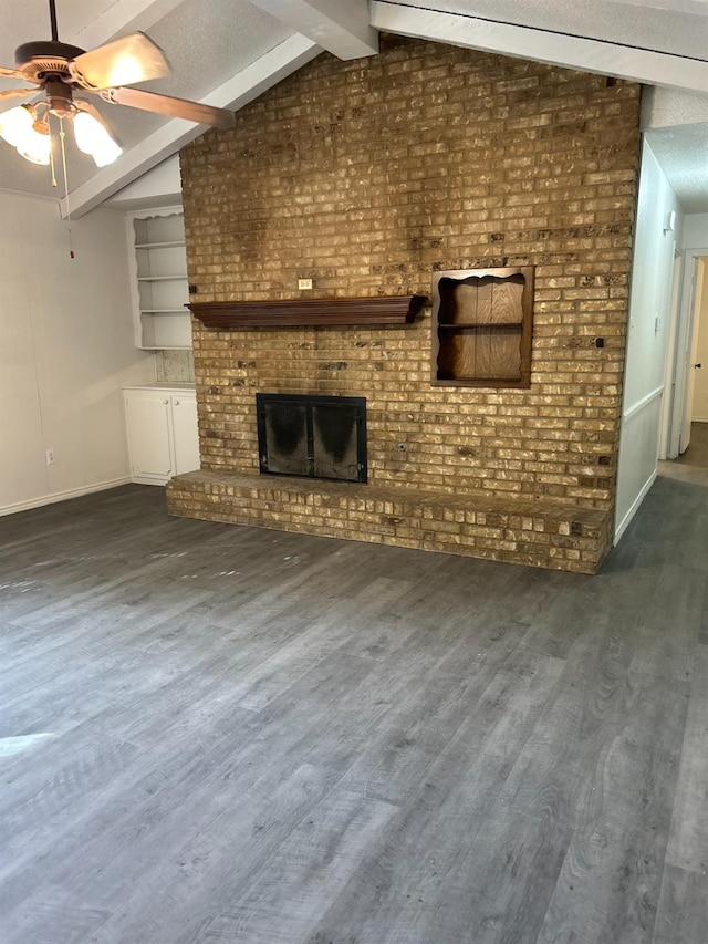 unfurnished living room featuring lofted ceiling with beams, a textured ceiling, dark hardwood / wood-style floors, ceiling fan, and a fireplace