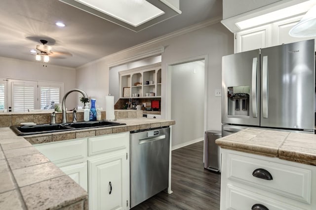 kitchen with white cabinetry, stainless steel appliances, tile countertops, and sink