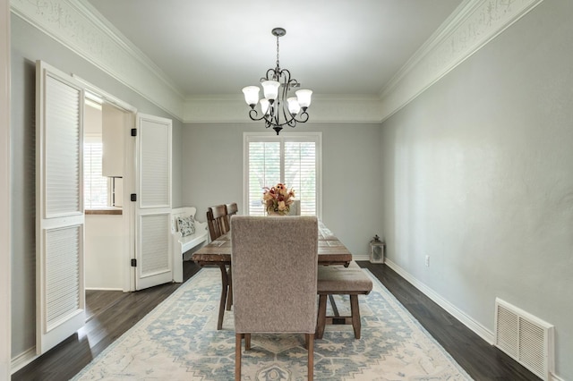 dining area with dark hardwood / wood-style flooring, ornamental molding, and a chandelier