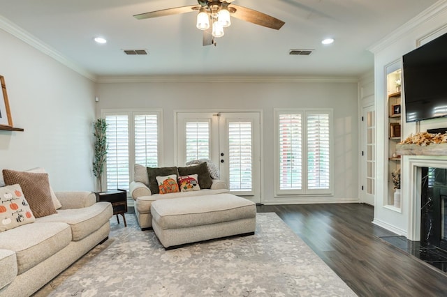 living room featuring crown molding, a high end fireplace, dark hardwood / wood-style floors, and french doors