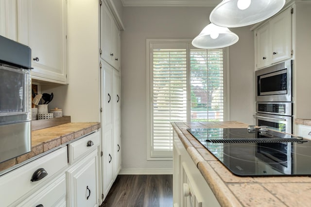 kitchen featuring stainless steel appliances, dark wood-type flooring, pendant lighting, and white cabinets