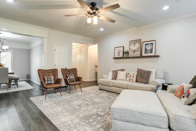 living room with ornamental molding, dark wood-type flooring, and ceiling fan with notable chandelier