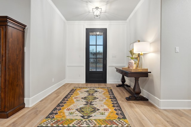 entrance foyer with ornamental molding and light hardwood / wood-style floors