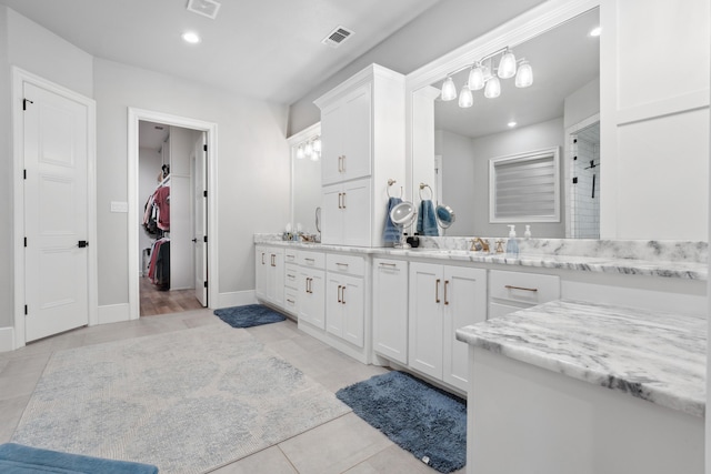 bathroom featuring vanity, tile patterned floors, and walk in shower