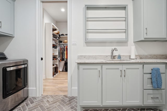 laundry room featuring cabinets, washer / clothes dryer, and sink