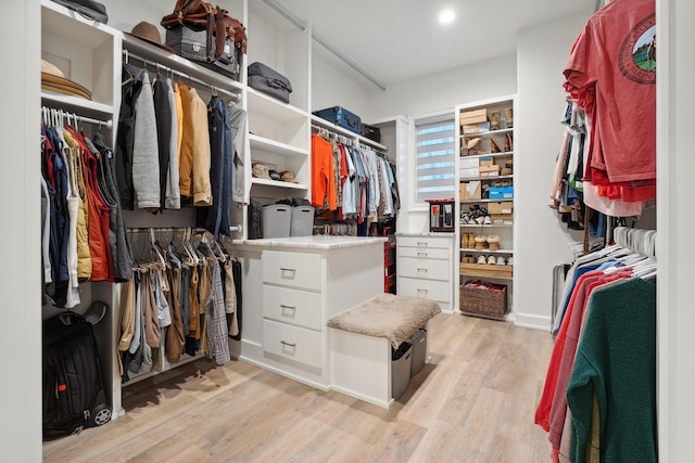 walk in closet with light hardwood / wood-style flooring