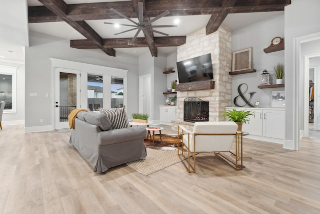 living room featuring a fireplace, beamed ceiling, ceiling fan, and light wood-type flooring