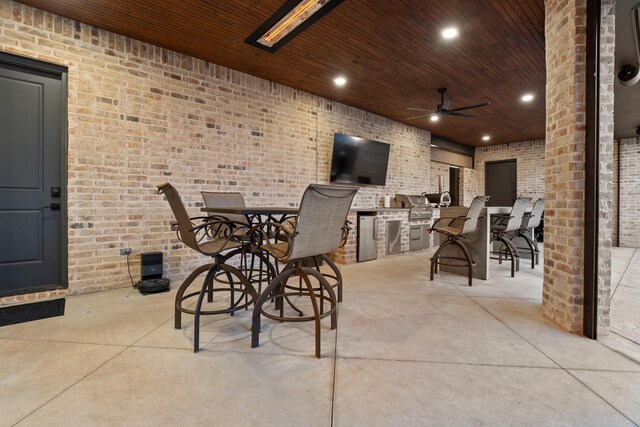 view of patio / terrace with a grill, ceiling fan, and an outdoor kitchen