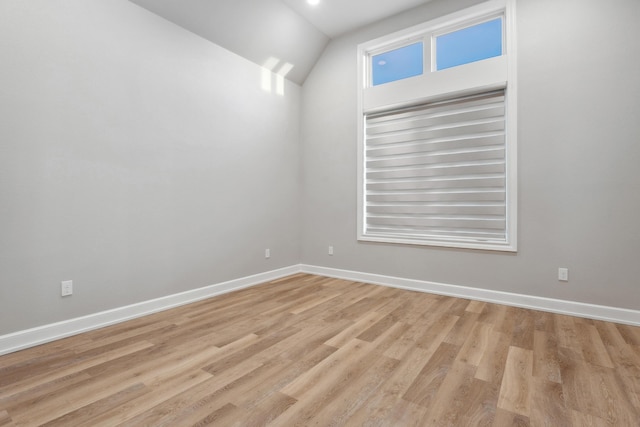 unfurnished room with lofted ceiling and light hardwood / wood-style floors